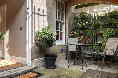 a patio with a table and chairs and flowers at Number 10 in Edinburgh