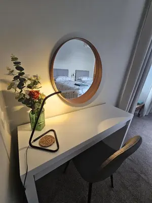 a desk with a mirror and a lamp on it at Glebe Apartment in Campbeltown