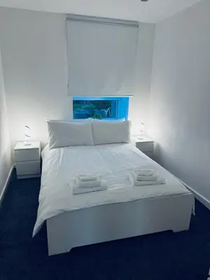 a bedroom with a white bed with two towels on it at Modern 2 bedroom House With Loft Conversion in Glasgow