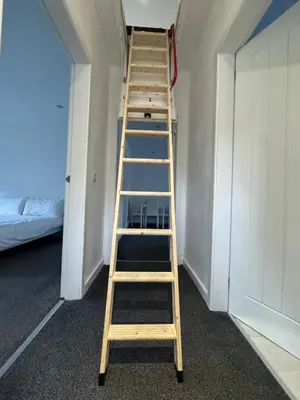 a wooden ladder in a room with a bed at Modern 2 bedroom House With Loft Conversion in Glasgow