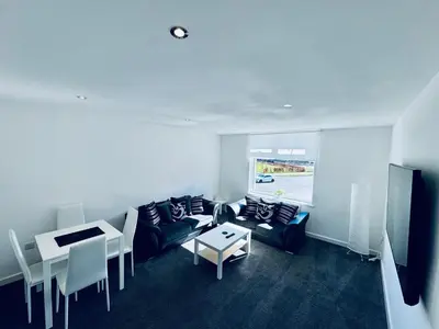 a living room with a couch and a table at Modern 2 bedroom House With Loft Conversion in Glasgow