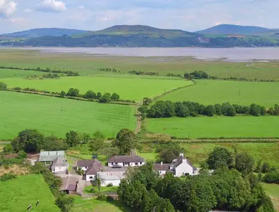 an aerial view of a house in a green field at Courtyard Cottages Granary Cottage in Wigtown
