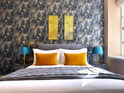 a bedroom with a large bed with two lamps at St Johns Jailhouse by the Castle in Stirling