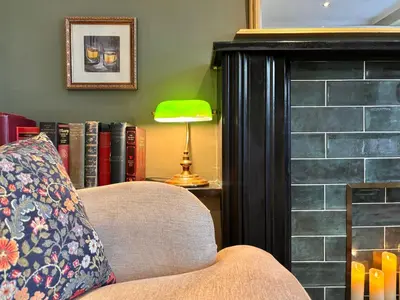 a living room with a couch and a lamp and books at St Johns Jailhouse by the Castle in Stirling