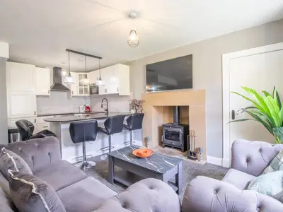 a living room with a couch and a table and a kitchen at Private Garden West End with Parking - Pass the Keys in Glasgow