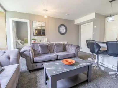 a living room with a couch and a table at Private Garden West End with Parking - Pass the Keys in Glasgow