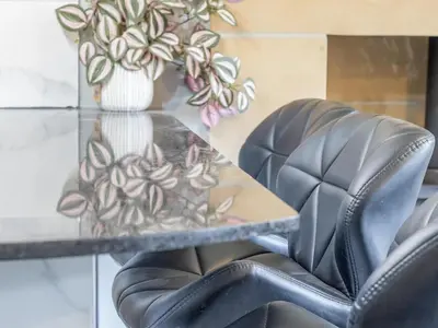 a glass table with a black leather chair and a plant at Private Garden West End with Parking - Pass the Keys in Glasgow