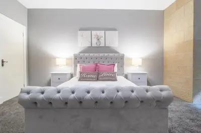 a bedroom with a large bed with pink pillows at Private Garden West End with Parking - Pass the Keys in Glasgow
