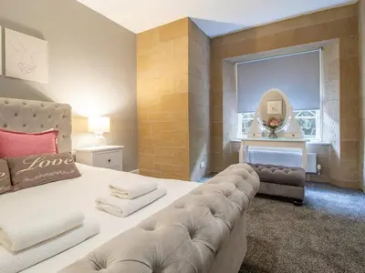 a bedroom with a couch and a mirror and a window at Private Garden West End with Parking - Pass the Keys in Glasgow
