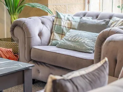 a couch with a pillow on it in a living room at Private Garden West End with Parking - Pass the Keys in Glasgow