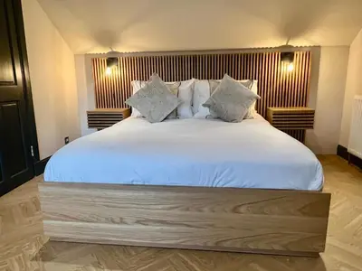 a bedroom with a large bed with white sheets and pillows at 9 Bedroom all Ensuite- Exclusive Use in Auchterarder