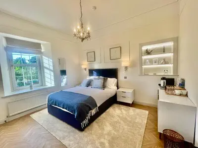 a bedroom with a bed and a chandelier at 'Hamish' in ApartNest Auchterarder in Auchterarder