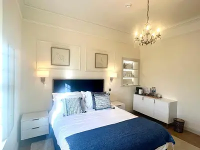 a bedroom with a large bed and a chandelier at 'Hamish' in ApartNest Auchterarder in Auchterarder