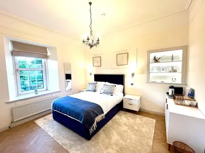 a bedroom with a bed and a chandelier at 'Hamish' in ApartNest Auchterarder in Auchterarder