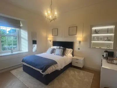 a bedroom with a bed and a chandelier at 'Hamish' in ApartNest Auchterarder in Auchterarder