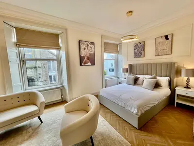 a bedroom with a bed and a chair at 'Flora' in ApartNest Auchterarder in Auchterarder