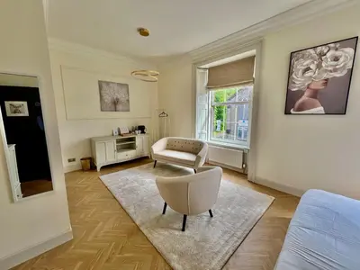 a living room with a couch and a chair at 'Flora' in ApartNest Auchterarder in Auchterarder
