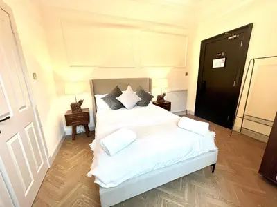 a bedroom with a bed with white sheets and pillows at 'Mac' in ApartNest Auchterarder in Auchterarder