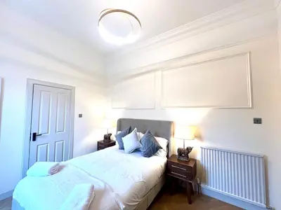 a bedroom with a bed with two night stands and two lamps at 'Mac' in ApartNest Auchterarder in Auchterarder