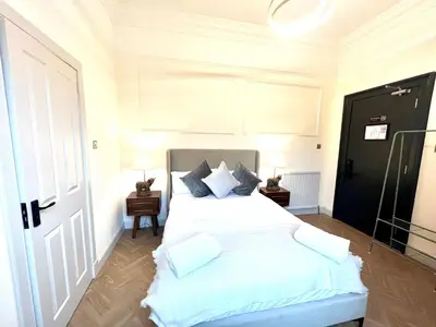 a bedroom with a bed with white sheets and pillows at 'Mac' in ApartNest Auchterarder in Auchterarder