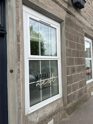 a window on a brick building with a parking sign in it at 'Blair' in ApartNest Auchterarder in Auchterarder
