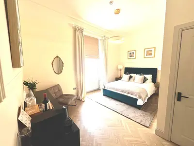 a bedroom with a bed and a chair and a window at 'Gordon' in ApartNest Auchterarder in Auchterarder