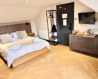 a bedroom with a large bed and a wooden floor at 'Clyde' in ApartNest Auchterarder in Auchterarder
