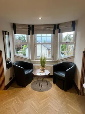 two chairs and a table in a room with windows at 'Clyde' in ApartNest Auchterarder in Auchterarder