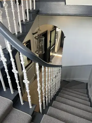a stairway with white and black stairs and a chandelier at 'Douglas' in ApartNest Auchterarder in Auchterarder