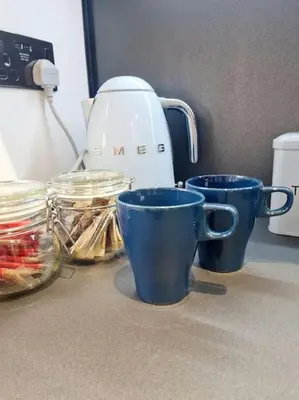 three blue cups sitting on a counter next to a mixer at Lovely house with back garden - PRIVATE driveway in Glasgow