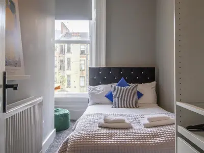 a small bedroom with a bed with a window at West End Cosy Pop of Colour - Pass the Keys in Glasgow