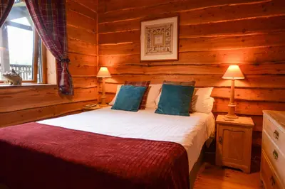a bedroom with a bed in a log cabin at Rowan Log Cabin in Dalavich