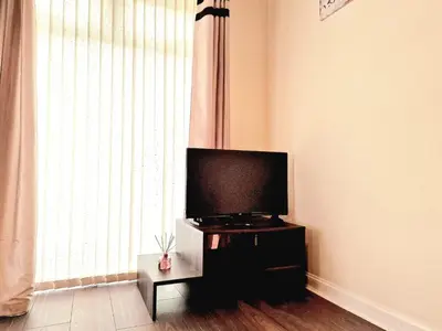 a living room with a flat screen tv on a stand at Yuriko in Saint Davids
