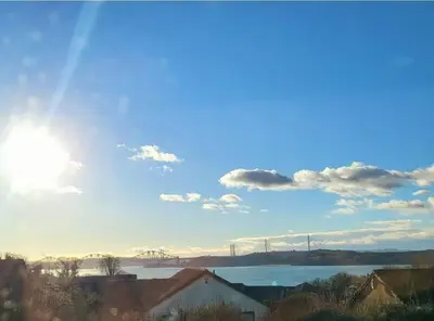 a view of a lake with the sun in the sky at Yuriko in Saint Davids