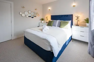 a bedroom with a large bed with towels on it at Quiet 2 bedroom gem in Stirling in Bridge of Allan