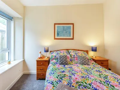a bedroom with a bed and two lamps and a window at Carraig Dhubh Cottage - Uk47123 in Whiting Bay