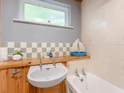 a bathroom with a sink and a tub and a window at Carraig-Dhubh South - Uk47124 in Whiting Bay