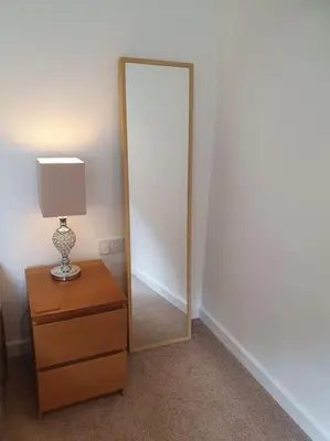 a mirror on a dresser next to a dresser with a lamp at THE ELFIN- Lovely 1 Bedroom - Free Parking in Bridge of Allan