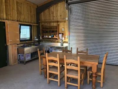a kitchen with a wooden table and chairs and a sink at The Bothy and Wagon at Pitmeadow Farm in Perth