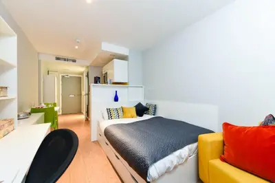 a bedroom with a bed and a yellow couch at Student Only Merchant Studios in Glasgow in Glasgow