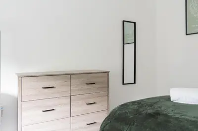 a bedroom with a chest of drawers and a mirror at 3 BDR House At Caledonia Luxe Stays Short Lets & Serviced Accommodation Tillicoultry in Tillicoultry