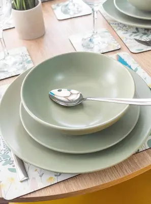 a green plate with a spoon on a table at 1 BDR Apt At Caledonia Luxe Stays Short Lets & Serviced Accommodation Paisley in Paisley