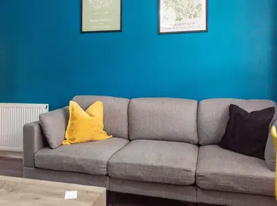 a gray couch with two yellow pillows in a living room at 1 BDR Apt At Caledonia Luxe Stays Short Lets & Serviced Accommodation Paisley in Paisley