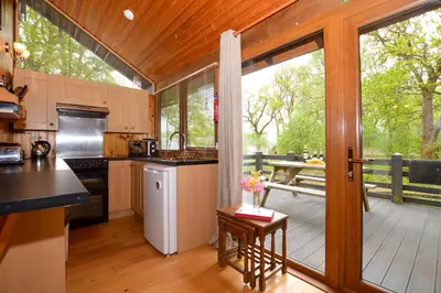 a kitchen with a large sliding glass door to a deck at Seil Log Cabin in Dalavich