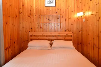 a bedroom with a bed in a wooden wall at Seil Log Cabin in Dalavich