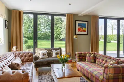 a living room with two couches and a table at Large and luxurious country home near Glasgow in Eaglesham