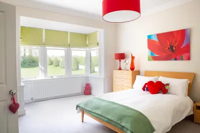 a bedroom with a bed with a red stuffed animal on it at Large and luxurious country home near Glasgow in Eaglesham