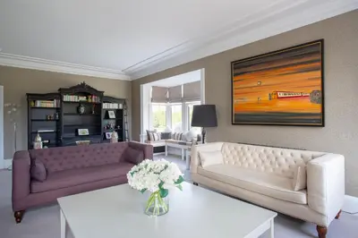 a living room with two couches and a table at Large and luxurious country home near Glasgow in Eaglesham