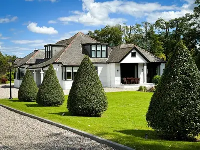 a white house with trees in front of it at Large and luxurious country home near Glasgow in Eaglesham
