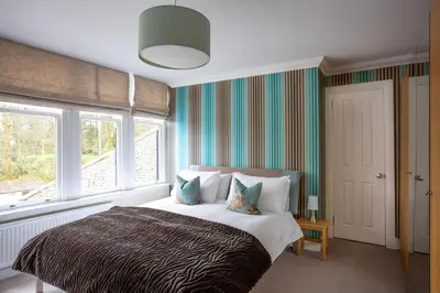 a bedroom with a large bed and a window at Large and luxurious country home near Glasgow in Eaglesham